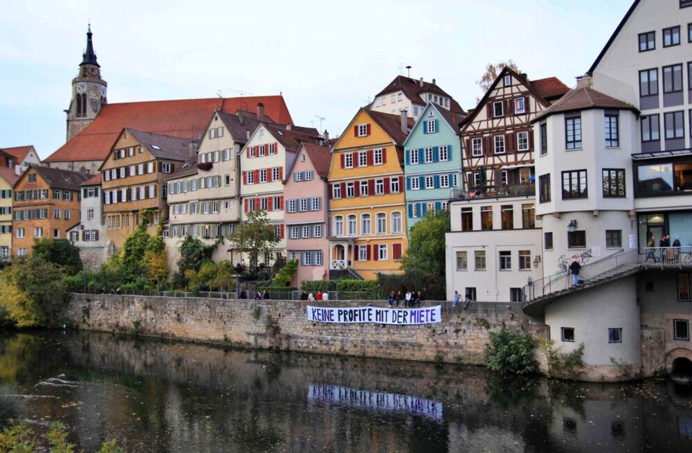 Aktion des Wohnraumbündnis TÜ für bezahlbare Mieten: großes Banner "keine Profite mit der Miete" an der Neckarfront in Tübingen